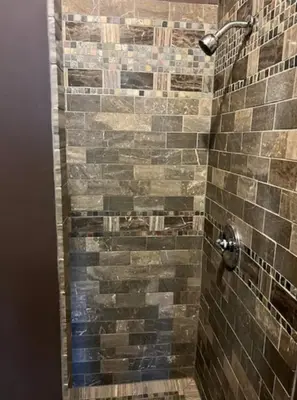 a bathroom with a shower with brown tiles at Soul Food 'Mont Morris' in New York