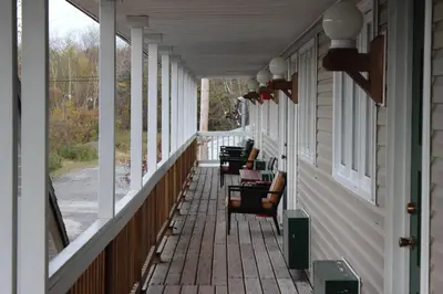 a row of chairs on the porch of a house at Berkshire Travel Lodge in Canaan