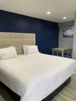 a bedroom with a large white bed with a blue wall at Dunmore Inn in Dunmore