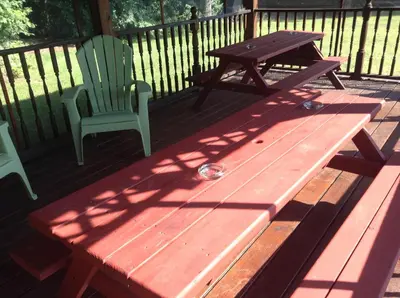 a wooden picnic table and a chair on a deck at Robin Hood Motel in Saratoga Springs