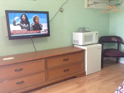 a room with a microwave and a tv on the wall at Robin Hood Motel in Saratoga Springs