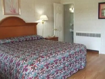 a bedroom with a large bed in a hotel room at Robin Hood Motel in Saratoga Springs