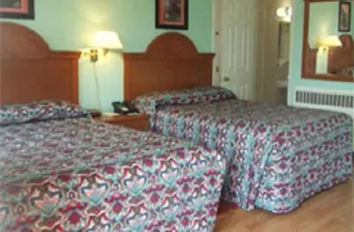 a hotel room with two beds and a mirror at Robin Hood Motel in Saratoga Springs