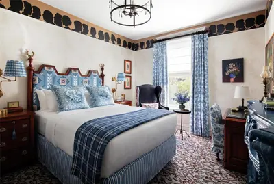 a bedroom with a blue and white bed and a window at Graduate by Hilton New Haven in New Haven