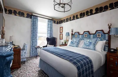 a bedroom with a blue and white bed and a window at Graduate by Hilton New Haven in New Haven