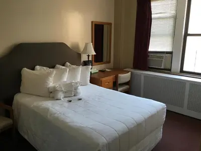 a hotel room with a large white bed with white pillows at Leo House in New York