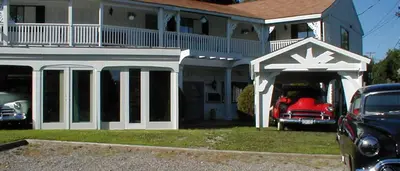 a house with a red car in a garage at Jenny's Country Manor in Stanfordville