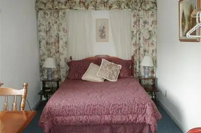 a bedroom with a bed with a red bedspread at Jenny's Country Manor in Stanfordville