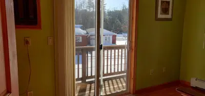 a door to a balcony with a view of a house at Red Ranch Inn in Catskill