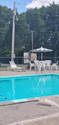 a swimming pool with a table and chairs and an umbrella at Red Ranch Inn in Catskill