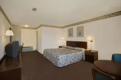 a hotel room with a bed and a table at Americas Best Value Inn Greenbush Albany in East Greenbush