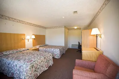 a hotel room with two beds and a chair at Americas Best Value Inn Greenbush Albany in East Greenbush