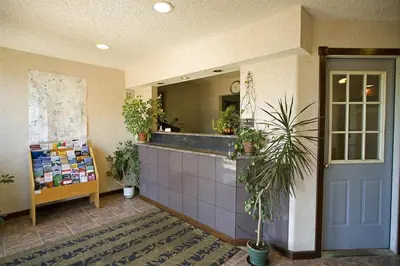 a lobby with a counter with plants and a mirror at Americas Best Value Inn Greenbush Albany in East Greenbush