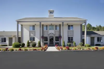 a large white house with a driveway at Americas Best Value Inn Greenbush Albany in East Greenbush