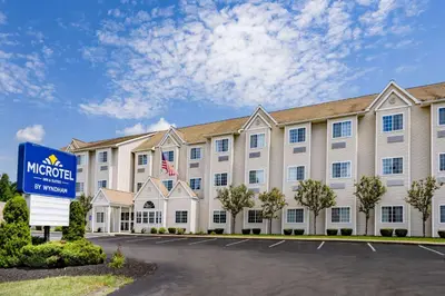 a hotel with a sign in front of a building at Microtel Inn & Suites by Wyndham Johnstown in Johnstown