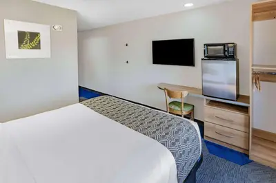 a hotel room with a bed and a desk at Microtel Inn & Suites by Wyndham Johnstown in Johnstown
