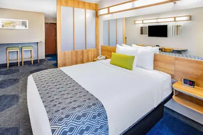 a hotel room with a bed and a kitchen at Microtel Inn & Suites by Wyndham Johnstown in Johnstown