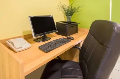 a desk with a computer monitor and a keyboard at Microtel Inn & Suites by Wyndham Johnstown in Johnstown