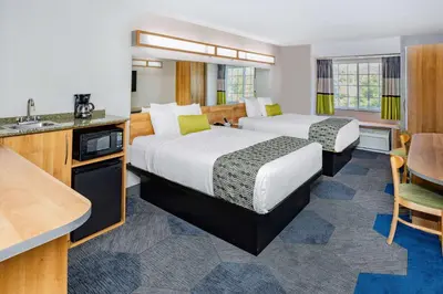 a hotel room with two beds and a kitchen at Microtel Inn & Suites by Wyndham Johnstown in Johnstown