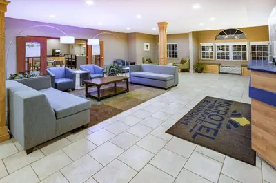 a lobby with couches and chairs and a bar at Microtel Inn & Suites by Wyndham Johnstown in Johnstown