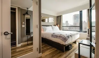 a bedroom with a bed and a large window at Pestana Park Avenue in New York