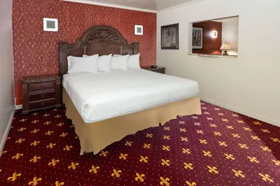 a hotel room with a bed and a red wall at Travelodge by Wyndham Manhasset in Manhasset