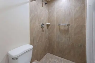 a bathroom with a shower with a toilet at Travelodge by Wyndham Manhasset in Manhasset
