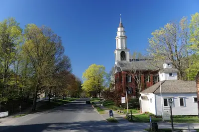 an empty street with a church with a steeple at Deerfield Inn in Deerfield