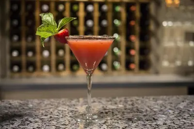 a cocktail with a strawberry in a glass on a counter at Deerfield Inn in Deerfield