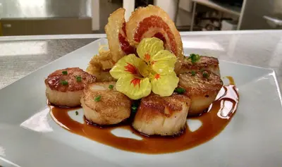 a plate of food with scallops and oranges on it at Deerfield Inn in Deerfield