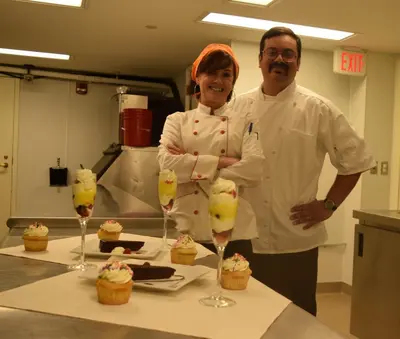 a man and a woman standing in a kitchen with cupcakes at Deerfield Inn in Deerfield