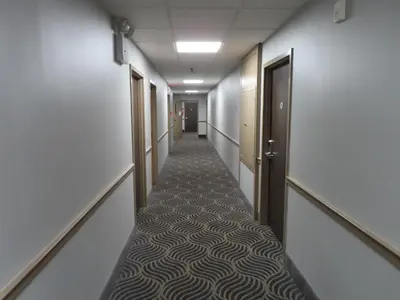 a corridor of an office with a long hallway with doors at St Charles Hotel Downtown Hudson in Hudson