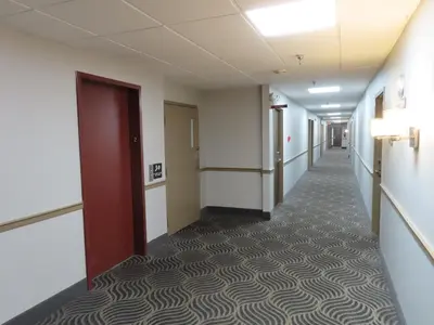 an empty hallway in an office building with a long corridor at St Charles Hotel Downtown Hudson in Hudson