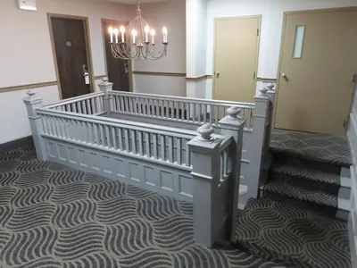 a hallway with a staircase with a chandelier at St Charles Hotel Downtown Hudson in Hudson