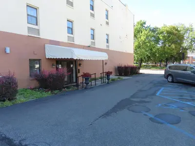 a car parked in a parking lot next to a building at St Charles Hotel Downtown Hudson in Hudson