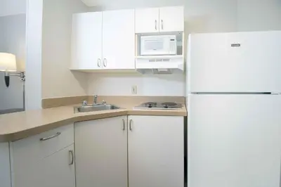 a kitchen with white cabinets and a white refrigerator at Extended Stay America Suites - Hartford - Farmington in Farmington