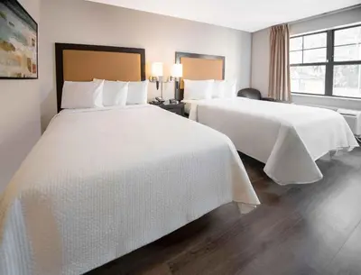 a hotel room with two beds with white sheets at Extended Stay America Suites - Hartford - Farmington in Farmington