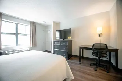 a hotel room with a bed and a desk and a television at Extended Stay America Suites - Hartford - Farmington in Farmington