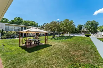 a picnic table with an umbrella in a park at Howard Johnson by Wyndham Albany in Albany