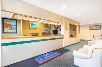 a lobby with a waiting room with white chairs at Howard Johnson by Wyndham Albany in Albany