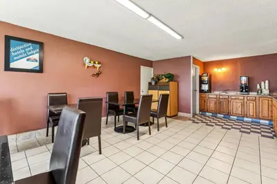 a restaurant with chairs and a table and a kitchen at Howard Johnson by Wyndham Albany in Albany