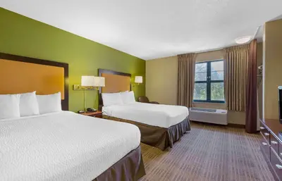 a hotel room with two beds and a window at Extended Stay America Select Suites - Hartford - Manchester in Manchester