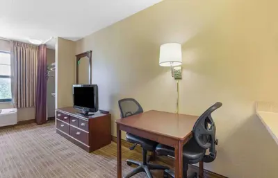 a hotel room with a desk and a tv and a room at Extended Stay America Select Suites - Hartford - Manchester in Manchester