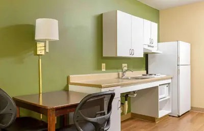 a kitchen with a sink and a table and a refrigerator at Extended Stay America Select Suites - Hartford - Manchester in Manchester