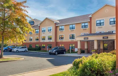 a large building with cars parked in a parking lot at Extended Stay America Suites - Hartford - Meriden in Meriden