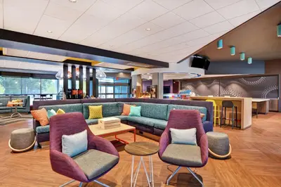 a lobby with a couch and chairs and a table at Tru By Hilton Middletown in Middletown