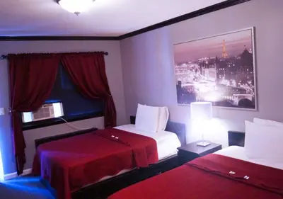 a hotel room with two beds and a window at Central Motel Courtyard in White Plains