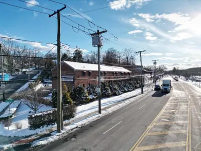 a truck driving down a road with snow on the ground at Central Motel Courtyard in White Plains