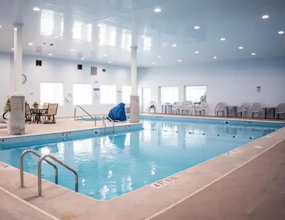 a large swimming pool with blue water in a building at Allen Lake Resort Richfield Springs Cooperstown in Richfield Springs