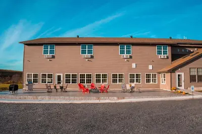 a large building with tables and chairs in front of it at Allen Lake Resort Richfield Springs Cooperstown in Richfield Springs